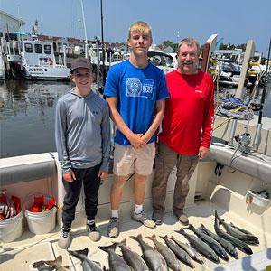 Group of 3 clients posing on the charter boat with the lake fish they caught