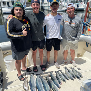 Group of 4 clients posing on the charter boat with the lake fish they caught