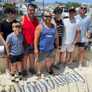 Group of 7 clients posing on the charter boat with the lake fish they caught