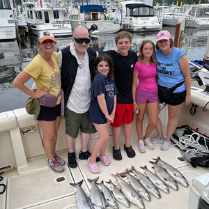 Group of 6 clients posing on the charter boat with the lake fish they caught