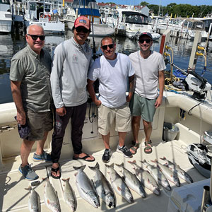 Group of 4 clients posing on the charter boat with the lake fish they caught