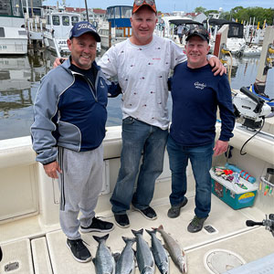 Group of 3 clients posing on the charter boat with the lake fish they caught