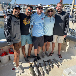 Group of 5 clients posing on the charter boat with the lake fish they caught