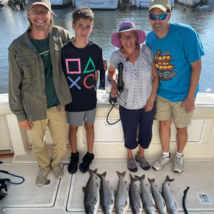 Group of 4 clients posing on the charter boat with the lake fish they caught