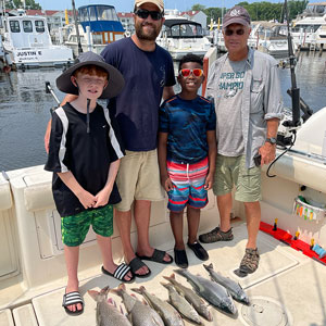 Group of 3 clients posing on the charter boat with the lake fish they caught