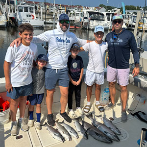 Group of 6 clients posing on the charter boat with the lake fish they caught